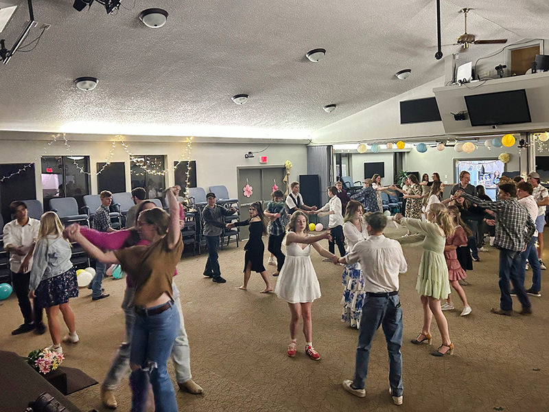 Students dancing in a room as couples doing a swing dance
